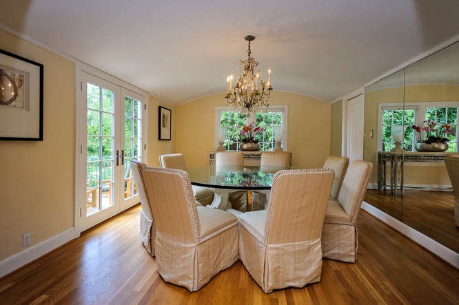 gracious formal dining room with arched ceiling and french doors opening to gardens