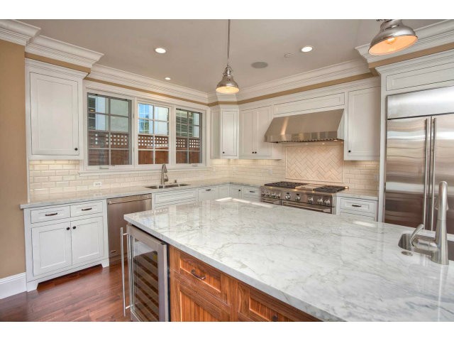 beautiful kitchen with custom cabinetry, top of the line appliances and marble countertops