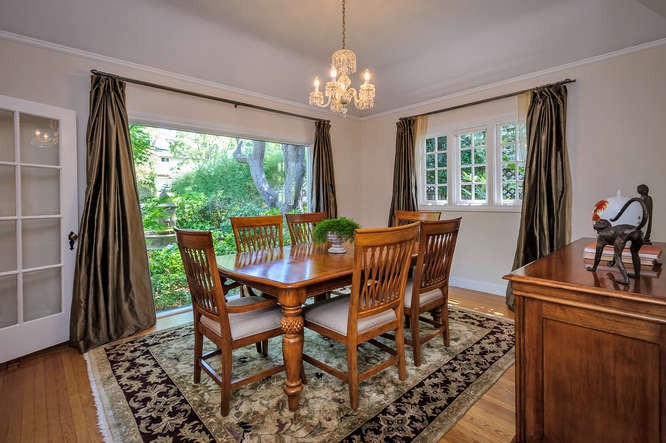 formal dining room with large windows overlooking lush gardens