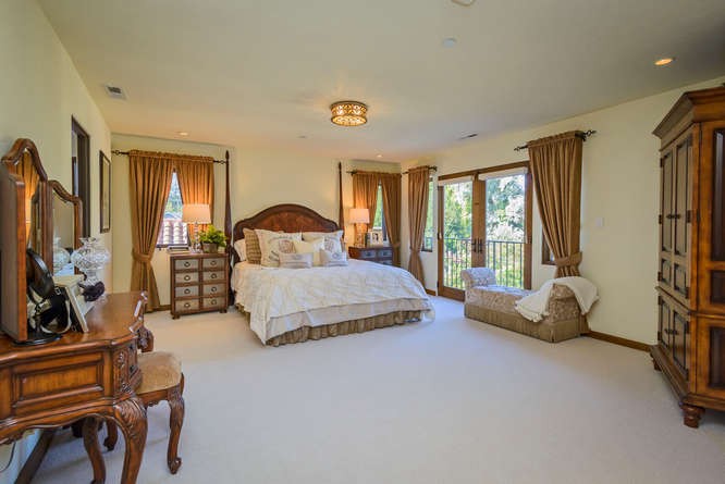 elegant and private master bedroom suite has a private balcony overlooking rear garden