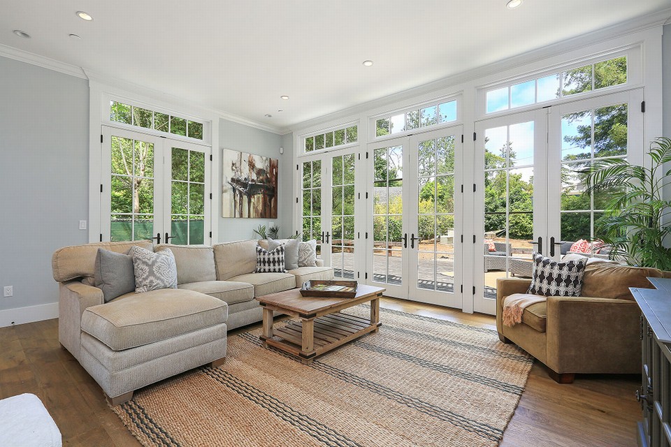 spacious family room with french doors leading to flat grassy yard & large decks