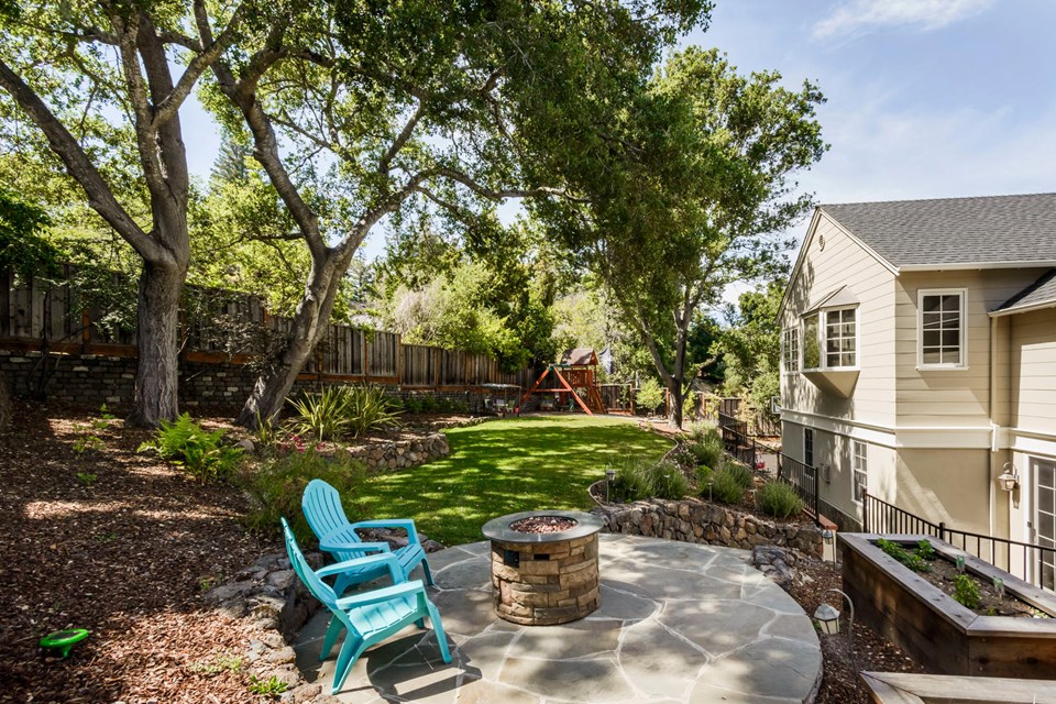 yard includes elegantly landscaped gardens, grassy lawns, children's play structure and vegetable garden